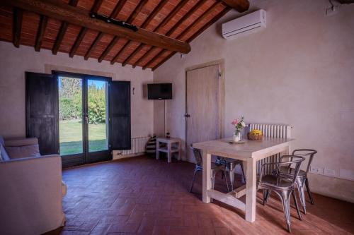a living room with a table and chairs and a television at Tenuta San Jacopo - Agriturismo in Cavriglia