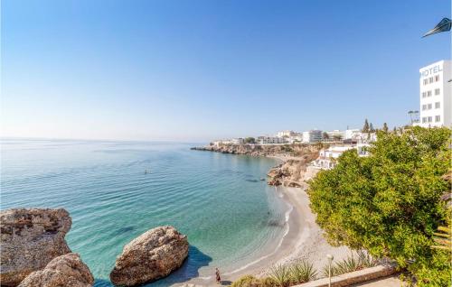 a view of a beach with rocks and buildings at Pet Friendly Home In Malaga in Málaga