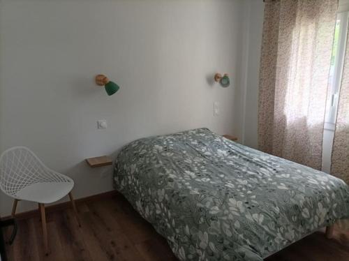 a bedroom with a bed and a chair and a window at Maison entièrement indépendante in Saint-Paul-lès-Dax