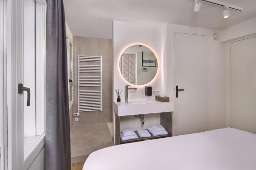 a bedroom with a bed and a sink and a mirror at Boutique Hotel DARQ in Maastricht