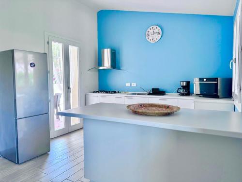 a blue kitchen with a counter with a bowl on it at Villa Neni - Key to Villas in Valledoria