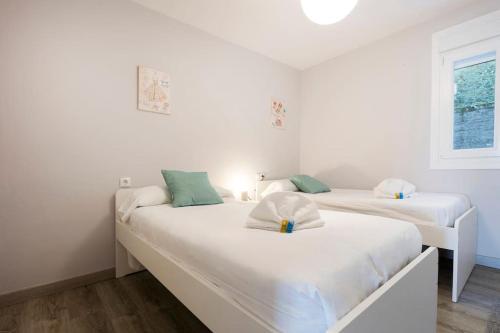 two beds in a room with white walls at Goizalde - Basquenjoy in Fuenterrabía