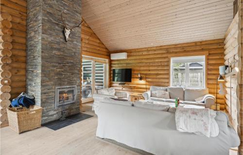 a living room with a large couch and a fireplace at Holiday Home Stræktorvet in Pollerup Kullegård