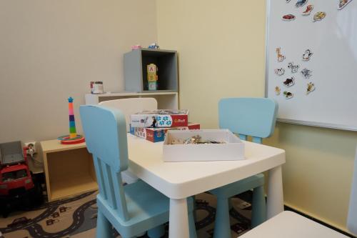 a table with two chairs and a box on it at Hotel Ski&Sky in Predeal