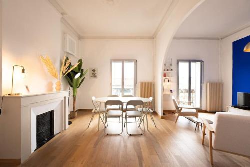un salon avec une table et des chaises et une cheminée dans l'établissement Le Majorelle, Grand T4, à Montpellier