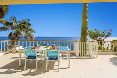a table and chairs on a balcony with the ocean at Villa Sea Shore by Villa Plus in Gaula