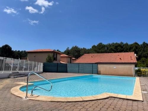 une grande piscine bleue dans une cour dans l'établissement Le petit pin, à Capbreton