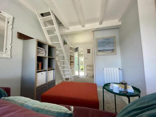 - un salon avec un escalier et un pouf rouge dans l'établissement Le petit pin, à Capbreton