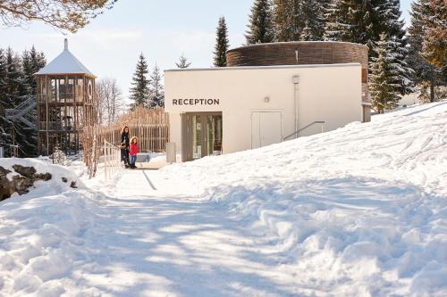 a person standing in the snow in front of a building at Reka-Feriendorf Montfaucon in Montfaucon