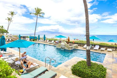 a pool at the beach with people sitting in chairs and umbrellas at KBM Resorts FREE CAR The Whaler Ocean view Studio with Stunning Sunset WH1-1218 in Kaanapali