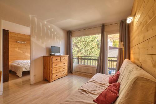 une chambre avec un lit et une fenêtre avec un balcon dans l'établissement Olympe - Les 2 Alpes, à Les Deux Alpes