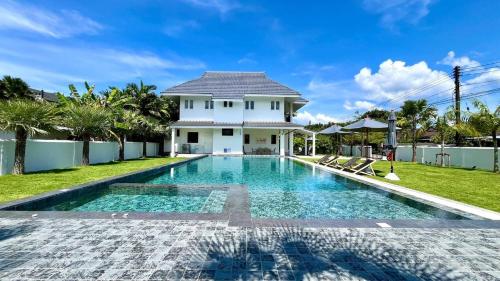 a house with a swimming pool in front of a house at Khaolak 16 meters-Pool Villa with 3 bedrooms 3 bathrooms-Kokotel Montana Hotel in Khao Lak