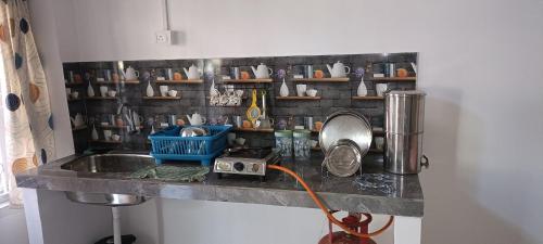 a kitchen with a sink and a counter with cups at Primrose Homestay in Guwahati
