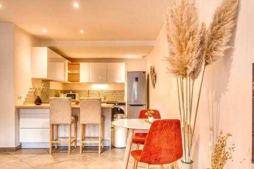 a kitchen with a table and some chairs at Le Bohème - Climatisé - Superbe T2 centre village in Brignais