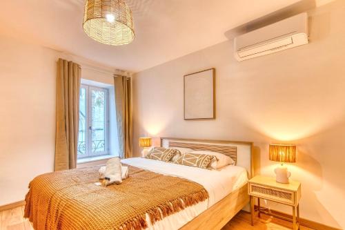 une chambre avec un lit sur lequel est allongé un chien dans l'établissement Le Bohème - Climatisé - Superbe T2 centre village, à Brignais