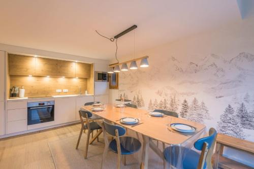 une cuisine avec une table et des chaises dans une pièce dans l'établissement Appartement Sérénité - Welkeys, à Chamonix-Mont-Blanc