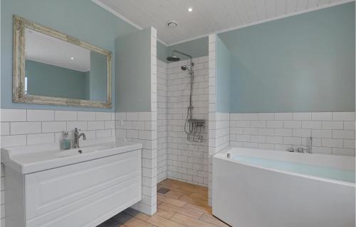 a white bathroom with a tub and a sink at Cozy Home In Aakirkeby With Kitchen in Vester Sømarken