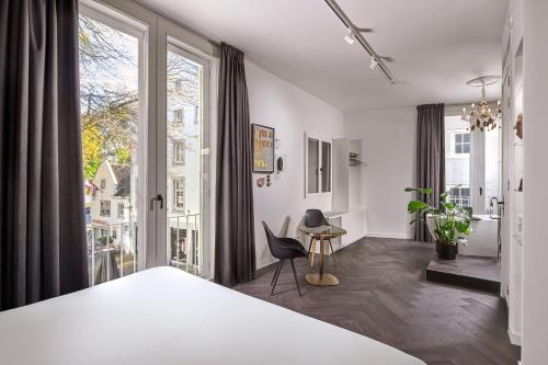 a bedroom with a bed and a large window at Boutique Hotel DARQ in Maastricht