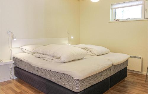 a bed with white sheets and pillows in a room at Amazing Home In Nexø With Wifi in Neksø