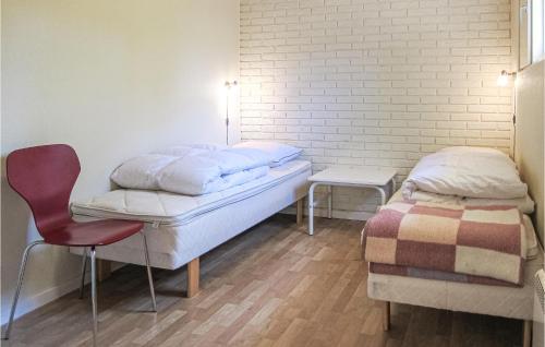 a room with two beds and a chair in it at Amazing Home In Nexø With Wifi in Neksø