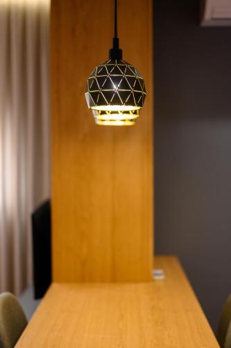 aendant light hanging over a wooden table at Adore Home in Tirana
