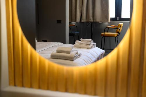 a mirror reflection of a bed with towels on it at Adore Home in Tirana