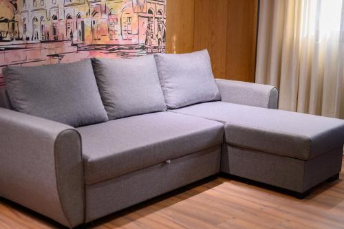 a grey couch in a room with a painting at Adore Home in Tirana