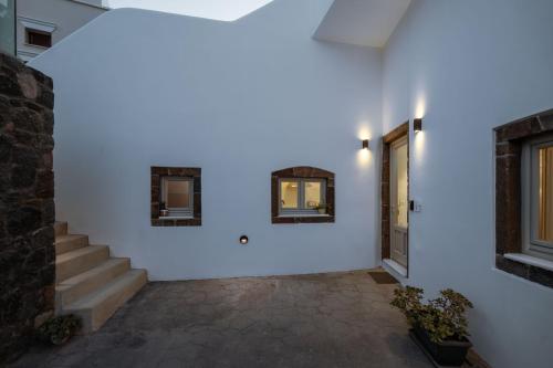 a hallway with white walls and stairs and a door at NEW Yiota Collection 4 Suites & 4 Prive Jacuzzi in Megalokhori