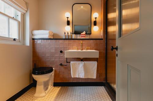 a bathroom with a sink and a toilet and a mirror at No.124 by GuestHouse, Brighton in Brighton & Hove