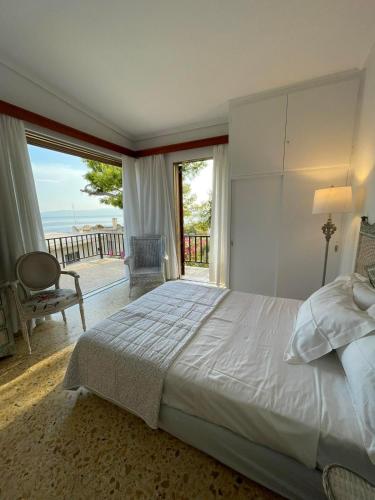 a bedroom with a bed and a view of the ocean at Saron Breeze Villa in Kineta
