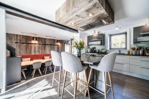 une cuisine et une salle à manger avec une table et des chaises dans l'établissement Chalet Aman Argentière Chamonix - by EMERALD STAY, à Chamonix-Mont-Blanc