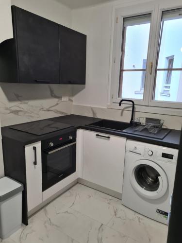 une cuisine avec un évier et une machine à laver dans l'établissement Tete d or, à Caluire-et-Cuire
