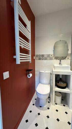 La salle de bains est pourvue de toilettes blanches et d'un sol noir et blanc. dans l'établissement Studio avec jardin, à Bègles