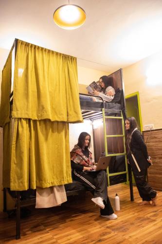 a group of people in a room with bunk beds at Trippy Turtle Hostel in Manāli