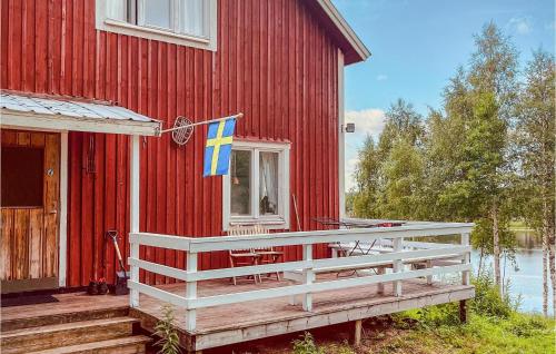a flag on the side of a red house at Gorgeous Home In Överkalix With Kitchen in Överkalix