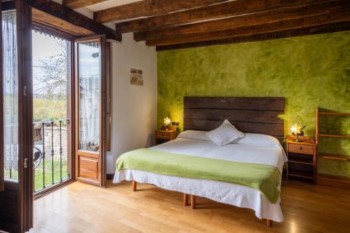 ein Schlafzimmer mit einem Bett mit einer grünen Wand in der Unterkunft Zadorra Etxea Casa in Salvatierra
