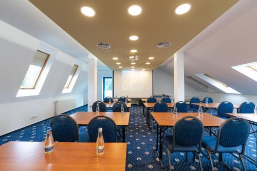 a conference room with tables and chairs and a whiteboard at Hotel Ski&Sky in Predeal