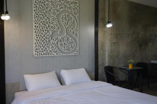 a bedroom with a bed with a picture on the wall at Phu Pha View Doi in Samoeng
