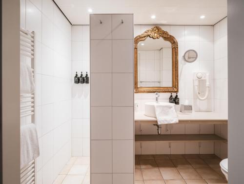 a bathroom with a sink and a mirror at Strandhotel Domburg in Domburg