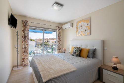una camera da letto con un letto grande e un balcone di Numar Residence A A a Vila Nova de Cacela