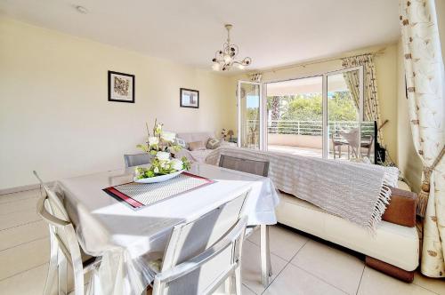 une salle à manger avec une table et un canapé dans l'établissement Lumineux 3 pieces proche centre ville A2B237, à Cannes