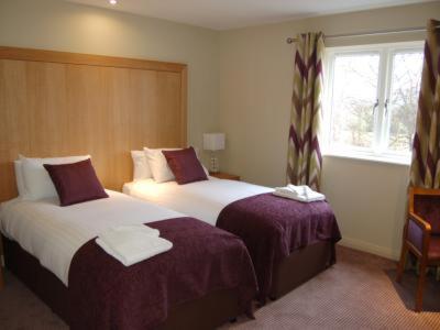 a hotel room with two beds and a window at Kings Court Hotel in Stratford-upon-Avon