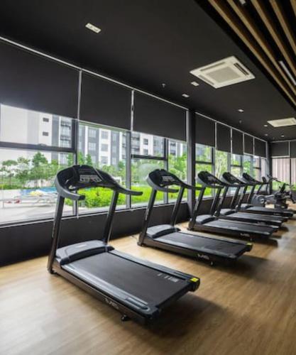 a row of treadmills in a gym with windows at 3 Room SplashMania Maya Bay Gamuda Cove Near KLIA in Banting