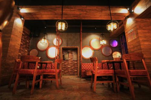 a dining room with red chairs and round mirrors at Imperial Heights in Deoghar