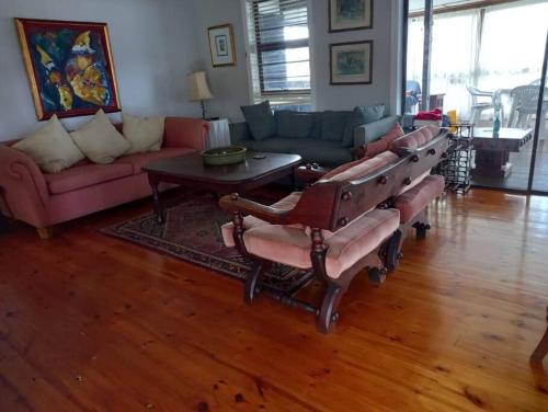 a living room with couches and a table at Jolly Mooi's Beach Break in Gxara