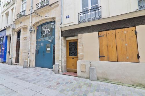 un groupe de bâtiments avec portes en bois dans une rue dans l'établissement Studio Quartier Saint-Michel Notre-Dame 4 Free Netflix, à Paris