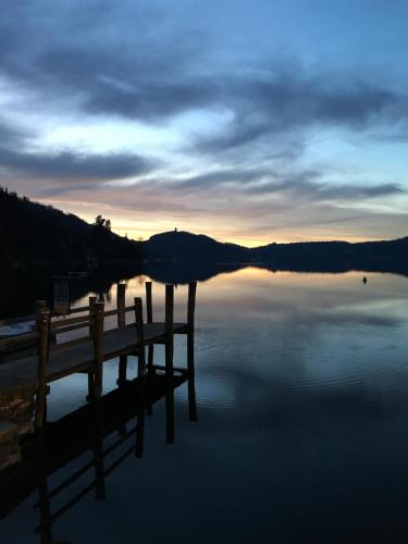 a view of a dock on a lake at sunset at -Ortaflats- Appartamento l'Isola in Orta San Giulio