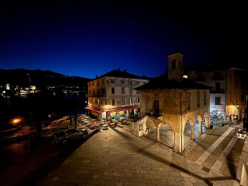 a building with a clock tower at night at -Ortaflats- Appartamento l'Isola in Orta San Giulio