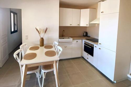 une cuisine avec une table et des chaises dans une pièce dans l'établissement Rez de villa Favone, à Conca