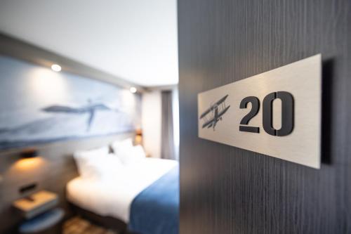 a hotel room with a sign on a wall at Best Western Saint Exupéry Eysines - Bordeaux Ouest in Eysines